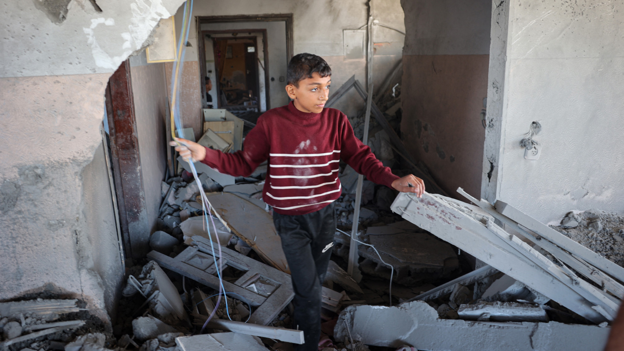 A child checks the rubble of a house hit by the overnight strikes (AFP)
