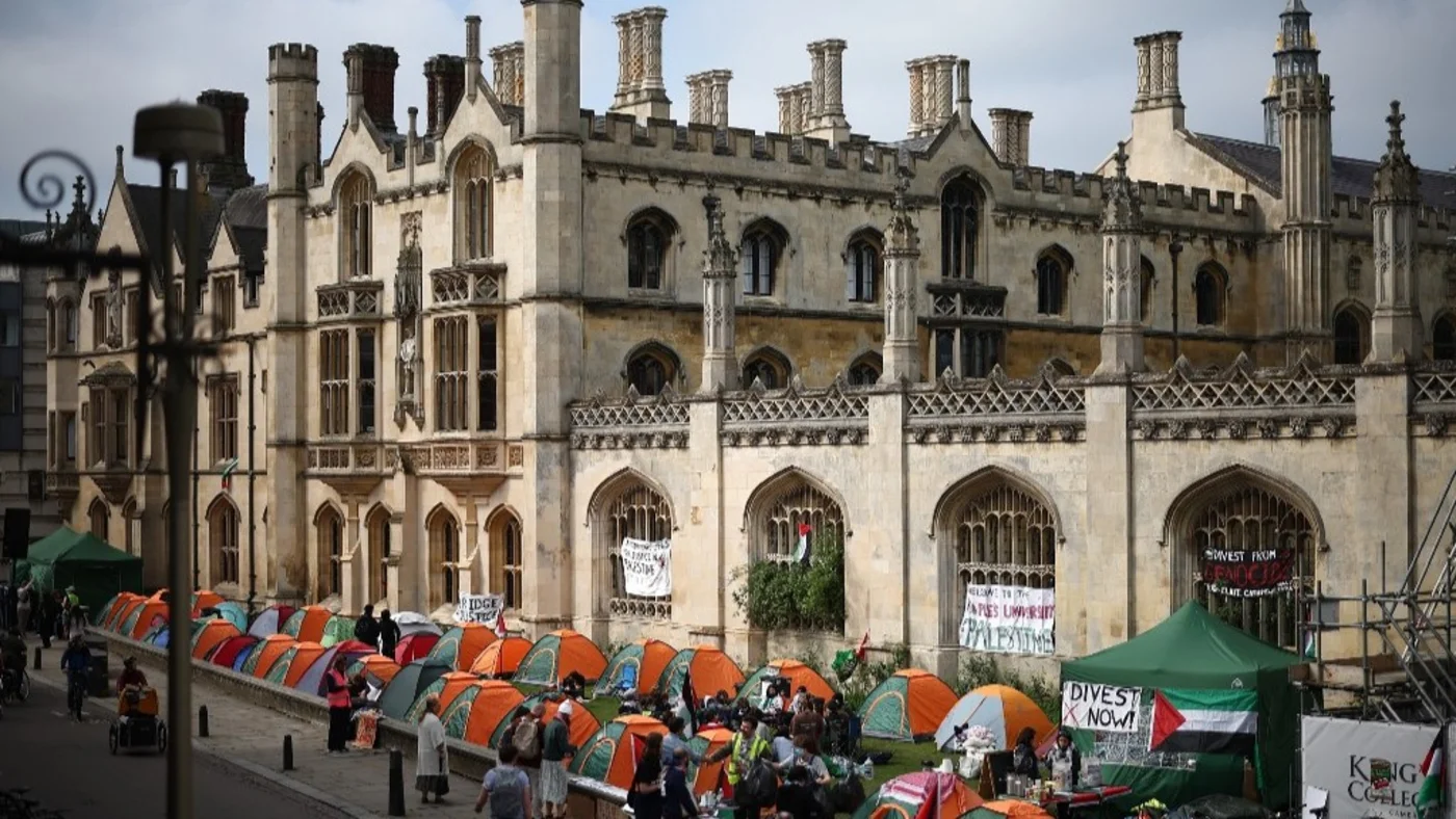 Students gather around their tents during a protest in support of Palestinian people, at King's College Cambridge on 8 May 2024 (AFP)