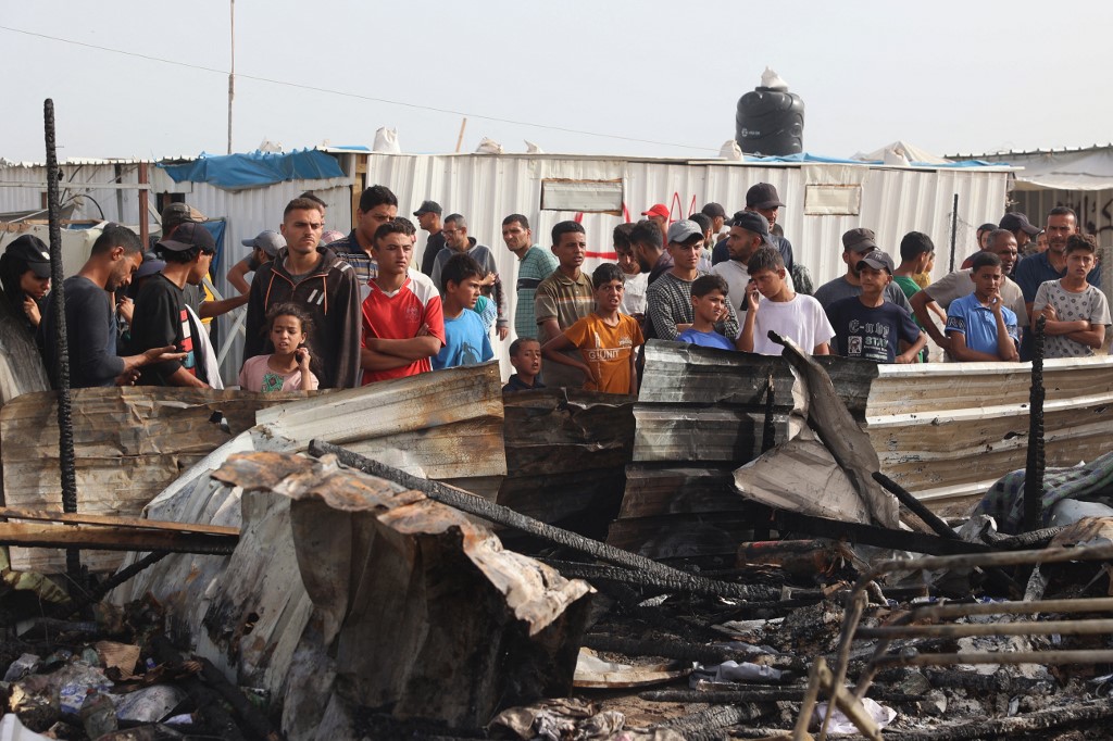 Des Palestiniens se rassemblent sur le site d’une frappe israélienne contre un camp de personnes déplacées à Rafah, le 27 mai 2024, qui a tué au moins 45 personnes (AFP)Des Palestiniens se rassemblent sur le site d’une frappe israélienne contre un camp de personnes déplacées à Rafah, le 27 mai 2024, qui a tué au moins 45 personnes (AFP)