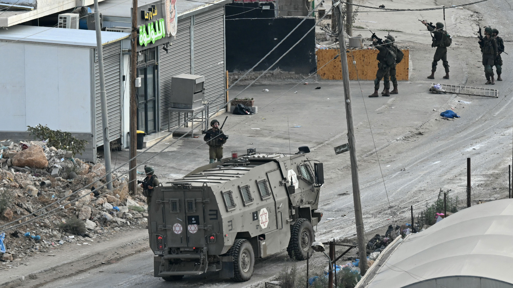 Israeli soldiers walk down a street during a raid in the al-Faraa camp for Palestinian refugees near Tubas city in the occupied West Bank on 28 August 2024 (AFP/Ronaldo Schemidt)