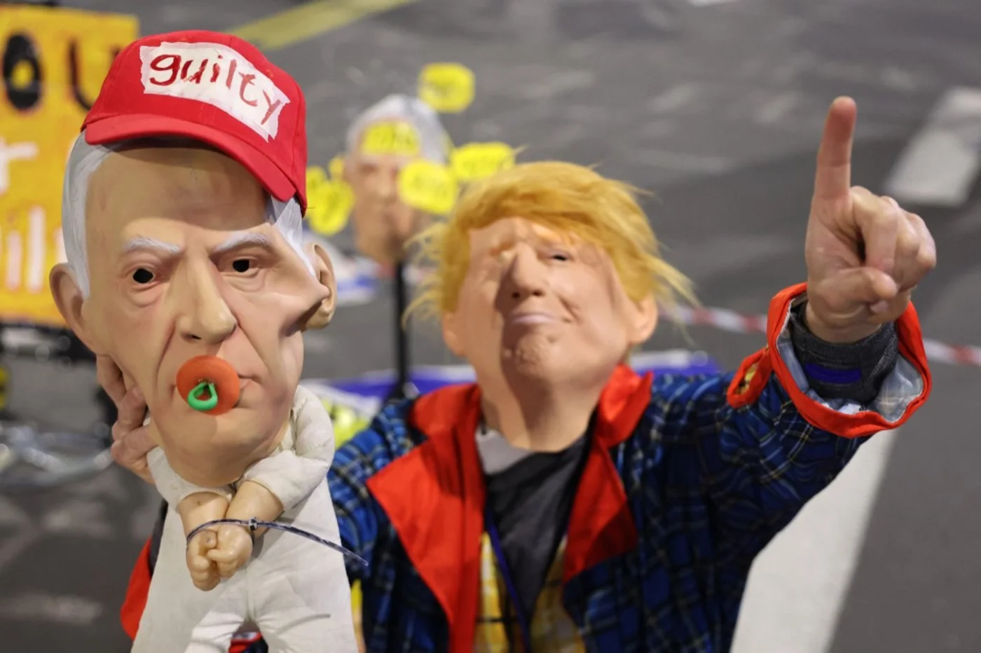 A demonstrator wearing a Donald Trump mask holds a doll with an Israeli Prime Minister Benjamin Netanyahu mask during a protest calling for the release of captives held in Gaza, Tel Aviv 1 February 2025 (Jack Guez/AFP)