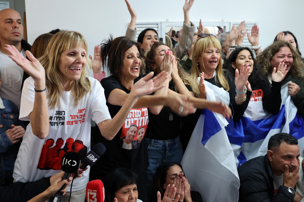 Relatives of Eli Sharabi cheer as they watch on a television screen his release along with two other captives in the Gaza Strip, at the family home in Tel Aviv on February 8, 2025.&nbsp;(Jack Guez/AFP)