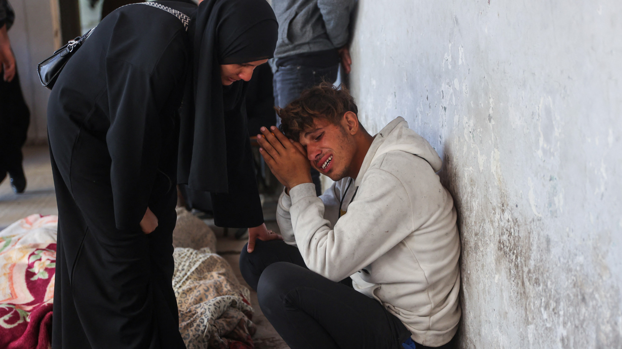 A woman consoles a grieving relative beside the body of a victim killed in an Israeli strike in Gaza City on 18 March 2025 (AFP/Omar al-Qattaa)