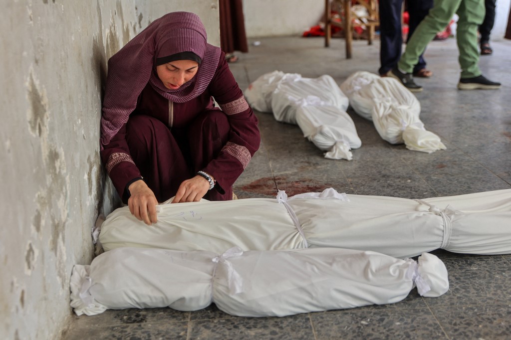 A woman mourns over the body of her relative, who was killed in an Israeli bombardment, at Al-Ahli Arab Hospital in Gaza City on March 26 2025. (AFP)