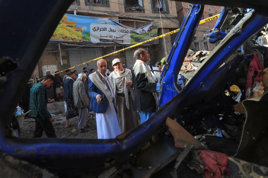 People assess the damage caused by a US airstrike in a neighbourhood in the Houthi-controlled Yemeni capital Sanaa on 21 April, 2025. (AFP)