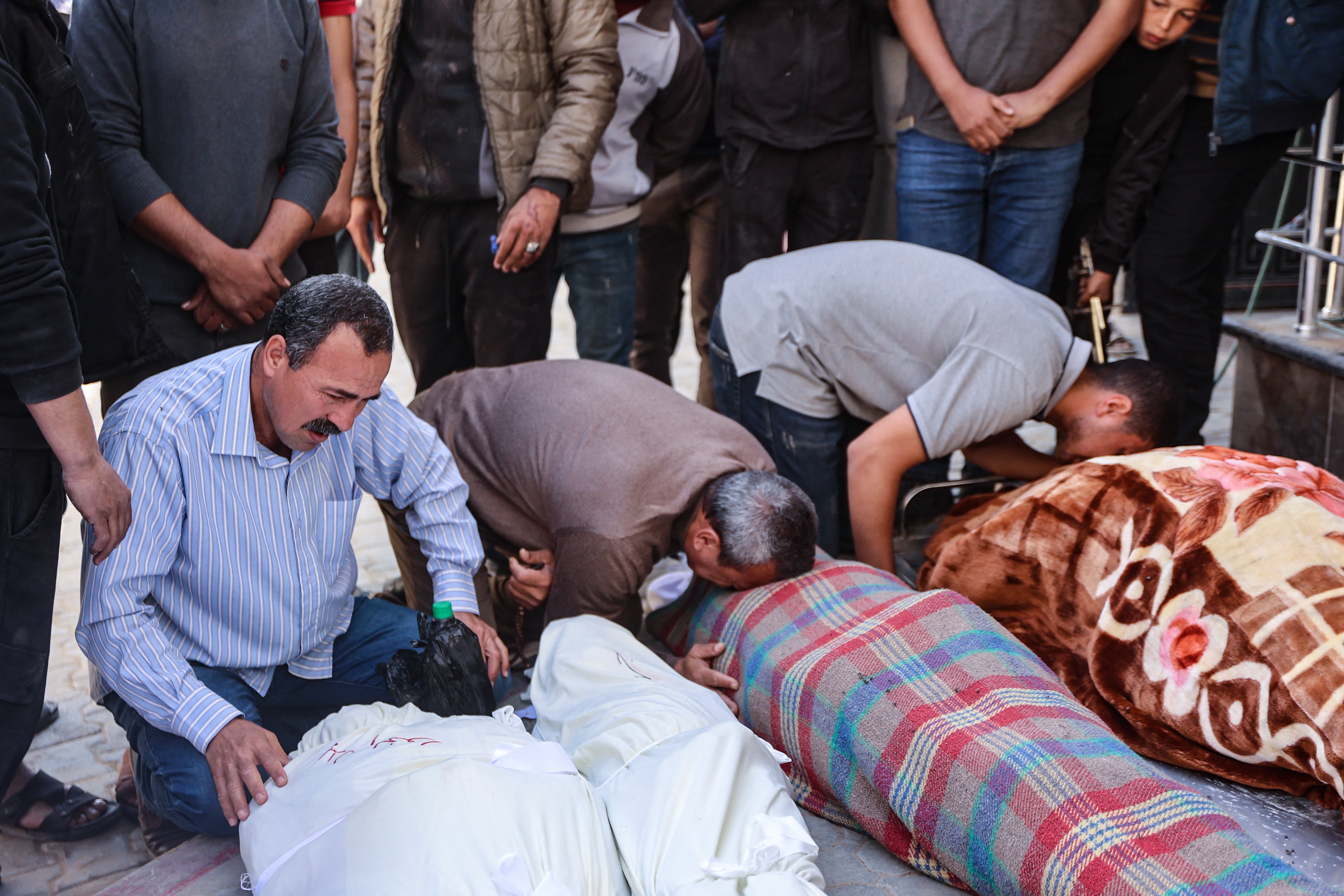​  Relatives mourn over the bodies of the Al-Khour family in the yard of the Al-Shifa hospital after their house was hit by an Israeli strike in Gaza City's Sabra neighbourhood on April 26, 2025.  ​