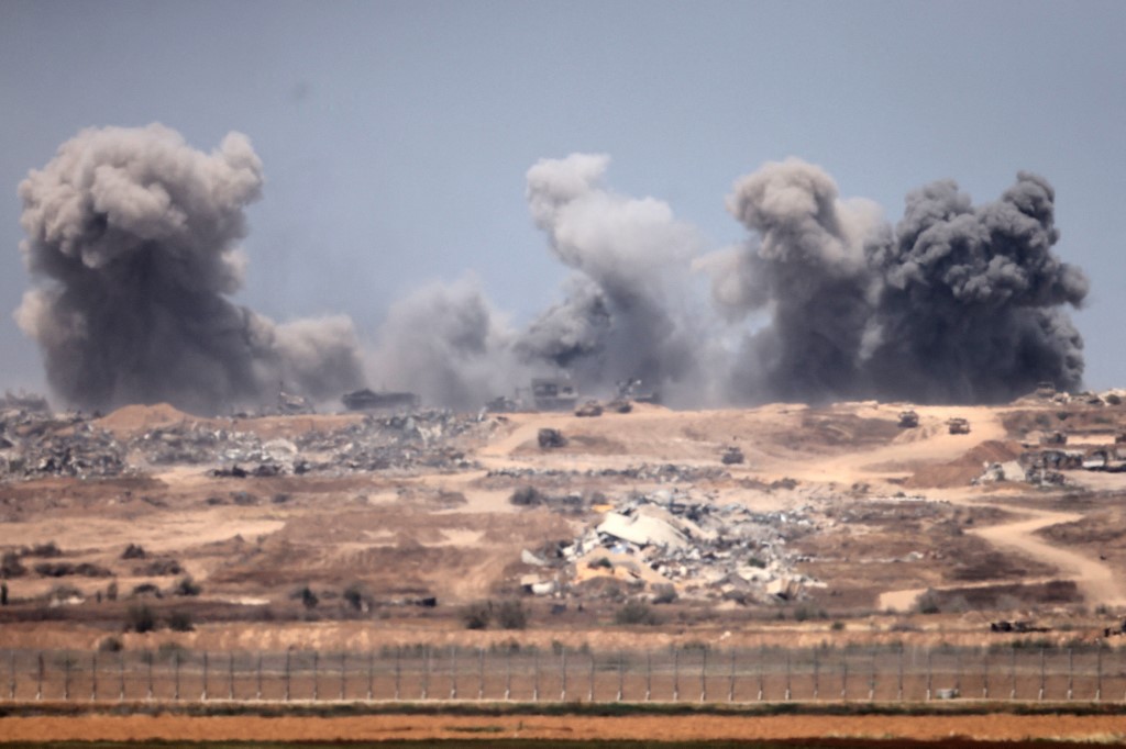 This picture taken from the Israeli side of the border with the Gaza Strip shows smoke plumes rising following explosions inside the Palestinian territory on 27 April, 2025. Menahem KAHANA / AFP