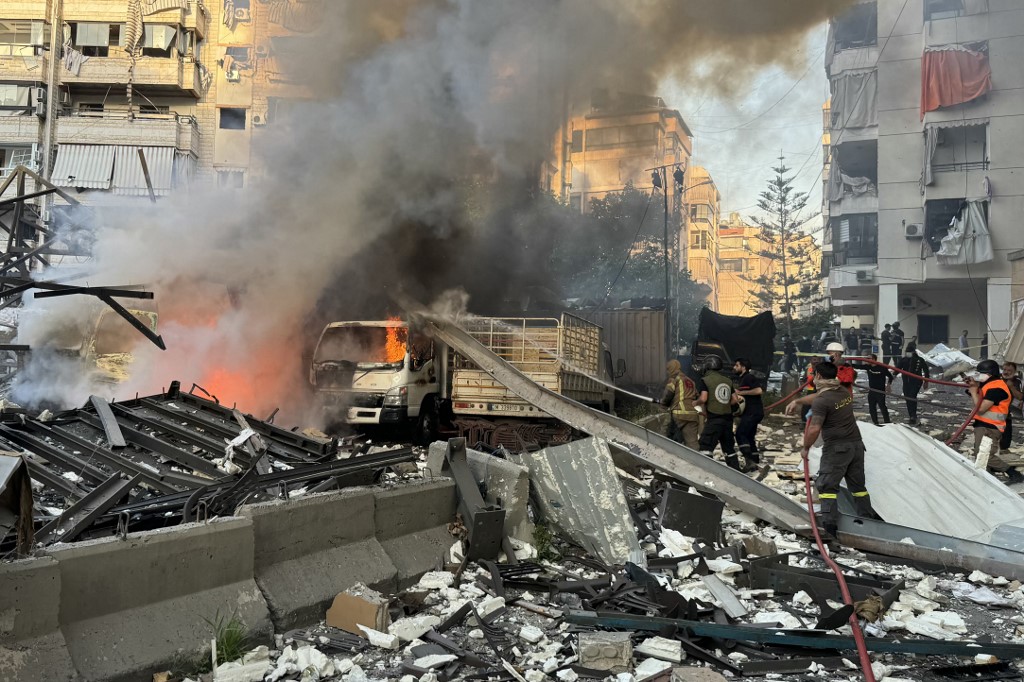 Lebenese Civil Defence rescuers extinguish a fire at a site hit in Israeli strikes following evacuation orders in Beirut's southern suburbs on April 27, 2025. AFP