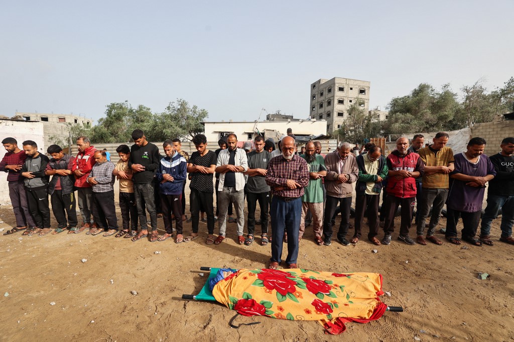 Relatives pray by the body of Palestinian eleven-year-old girl Rimas Obeid, who was killed in Israeli strikes on Al-Hasanat mosque at the Nuseirat refugee camp in the central Gaza Strip on May 12, 2025.