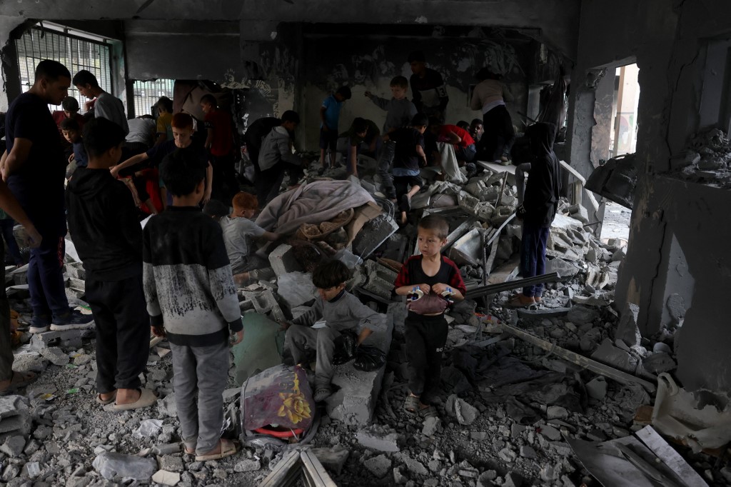Palestinians salvage items from the rubble of the Fatima Bint Asad school hit in overnight Israeli strikes in Jabalia in the northern Gaza Strip on May 12, 2025.