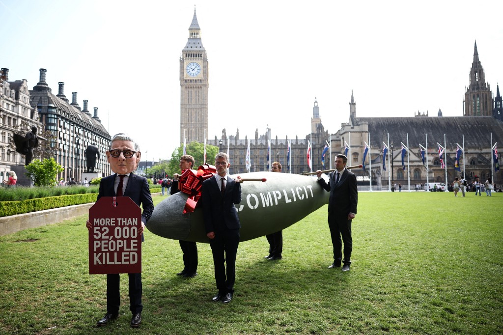 A protestor dressed as Britain's Prime Minister Keir Starmer poses in front of a 16-foot replica of a MK-84 2,000-pound bomb labelled with the word 