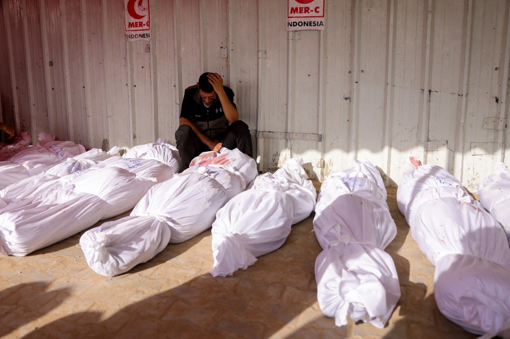 A Palestinian man reacts as he mourns among the bodies of victims of Israeli strikes on Jabalia, at the Indonesian Hospital in Beit Lahia in the northern Gaza Strip on May 14, 2025. 