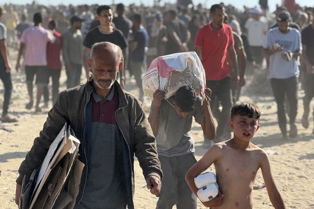 Displaced Palestinians receive food packages from a US-backed foundation pledging to distribute humanitarian aid in western Rafah in the southern Gaza Strip on May 27, 2025.