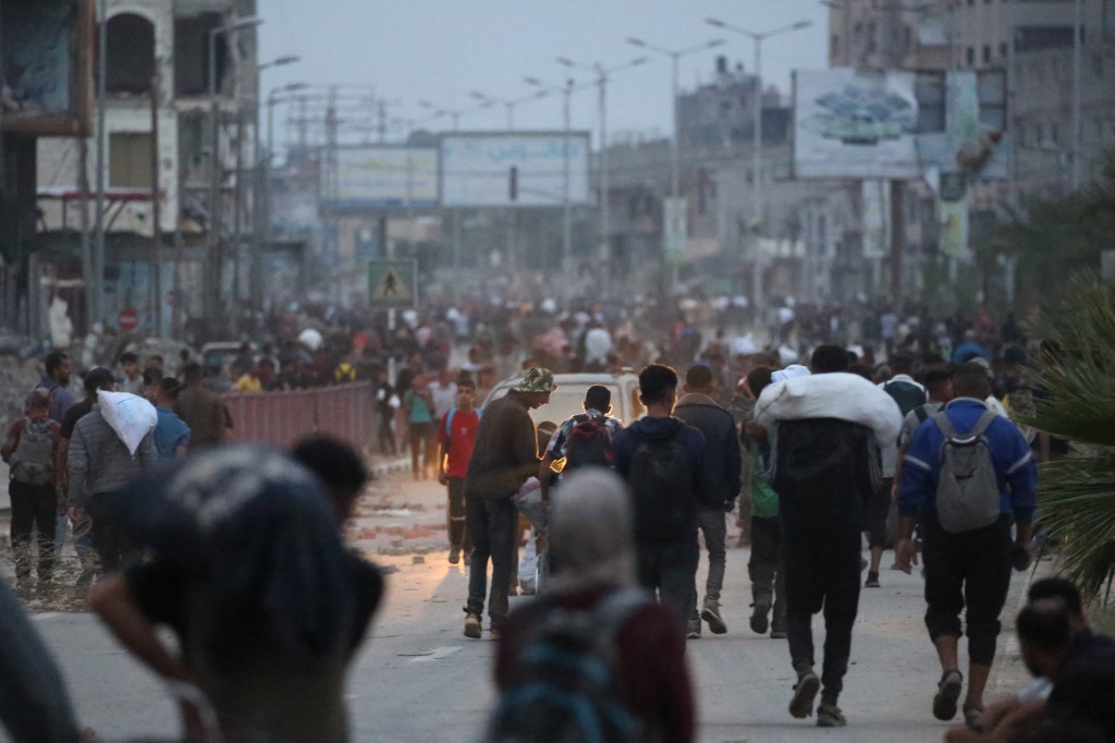 Palestinians carry humanitarian aid back from a distribution point in the Bureij camp for Palestinian refugees in the central Gaza Strip early on June 9, 2025.