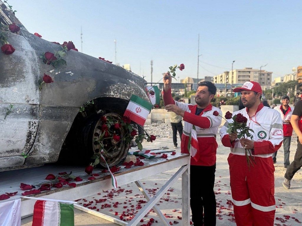 This handout picture provided by the Iranian Red Crescent on June 23, 2025 shows Iranian Red Crescent medics placing roses on an ambulance, that was targeted in an Israeli strike, as it displayed in Tehran. 