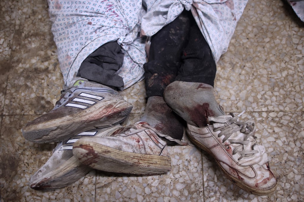 Blood-stained shoes are pictured with bodies of people were killed during overnight Israeli strikes, at the morgue of Al-Shifa hospital in Gaza City on June 26, 2025, 