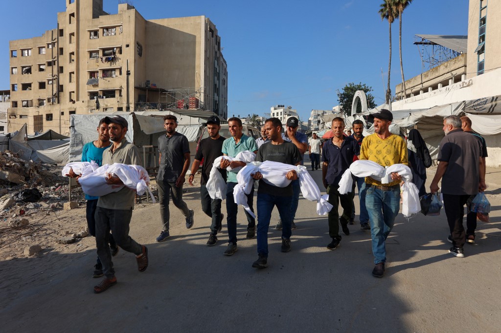 Palestinian men carry the bodies of children killed earlier in the day in an Israeli strike in Gaza City, during a funeral precession from Baptist Hospital to a cemetary, on July 2, 2025, 