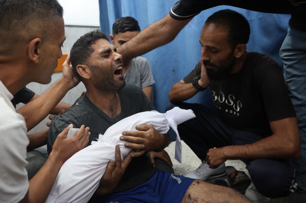 Ahmad mourns as he carries the shrouded body of his 6-month-old son Yahya Sayyam, who was killed in a reported Israeli strike, at the al-Shifa hospital in Gaza City on July 7, 2025.