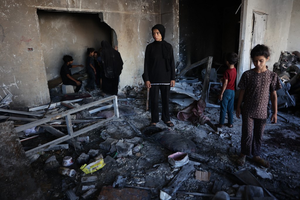 People inspect the damage after a reported Israeli strike on a clinic-turned-shelter in the northern Al-Rimal neighborhood of Gaza City on July 7, 2025.