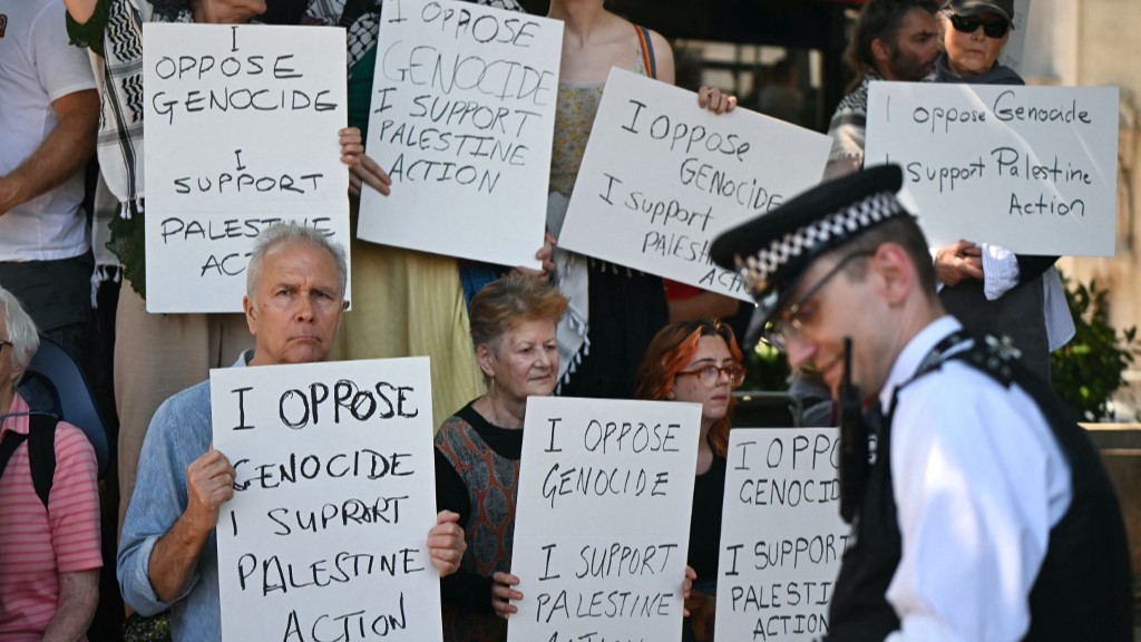 A Police officer walks past as protesters gather in support of the pro-palestinian group 