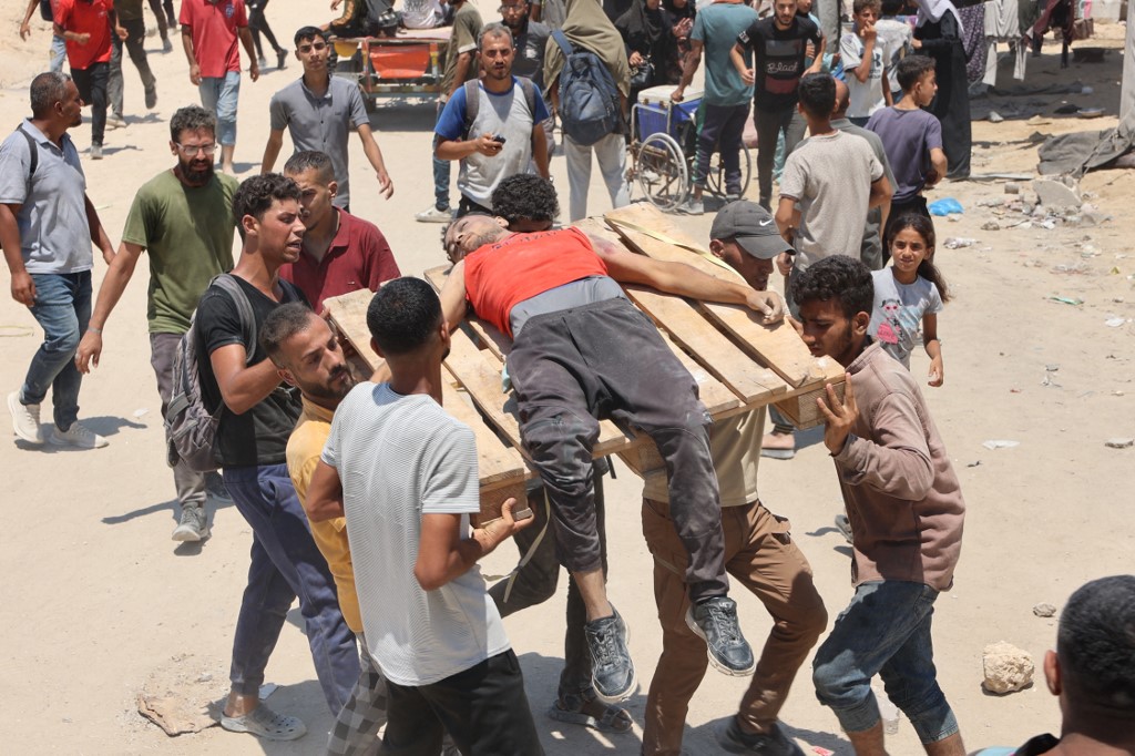 People transport a Palestinian youth, wounded in a stampede he waited for humanitarian aid along al-Rashid street in western Jabalia on July 22, 2025. AFP
