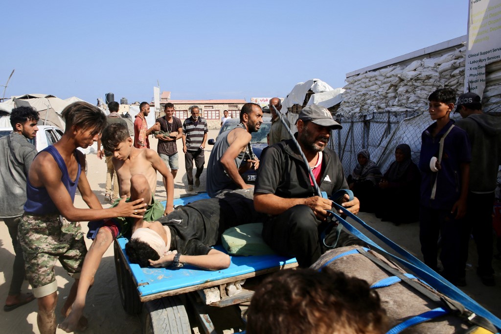 A Palestinian man who was injured while seeking humanitarian aid at the Rafah corridor, is transported into a field hospital in the Mawasi area of Rafah in the southern Gaza Strip on July 30, 2025. (AFP)
