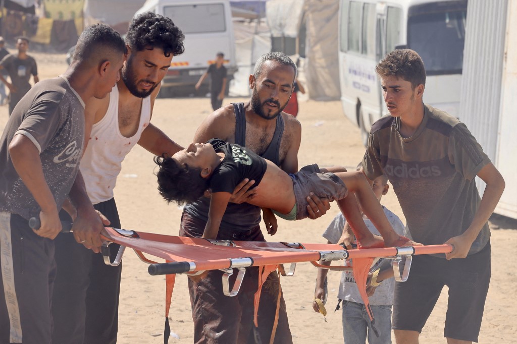 A Palestinian boy who was injured while seeking humanitarian aid at the Rafah corridor, is carried into a field hospital in the Mawasi area of Rafah in the southern Gaza Strip on July 30, 2025. 