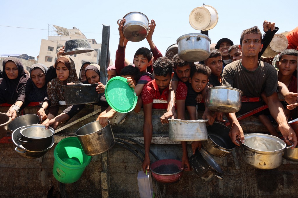 Palestinians receive lentil soup at a food distribution point in Gaza City on August 2, 2025. The World Health Organisation warned on July 27 that malnutrition was reaching 