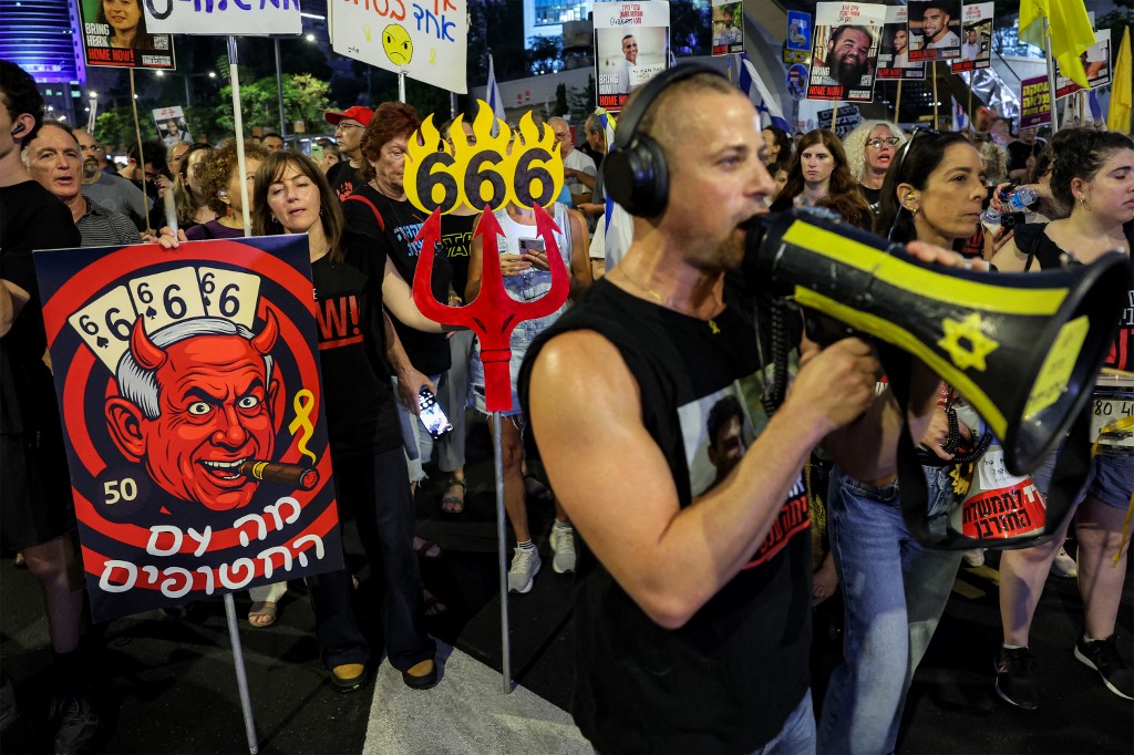 A demonstrator speaks on a megaphone during an anti-government protest calling for action to secure the release of Israeli captives.