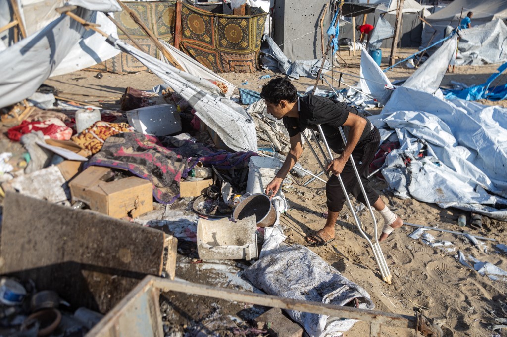 Palestinians inspect the damage at the site of an overnight Israeli strike on a tent sheltering displaced people, in Khan Younis, southern Gaza Strip, August 5, 2025.