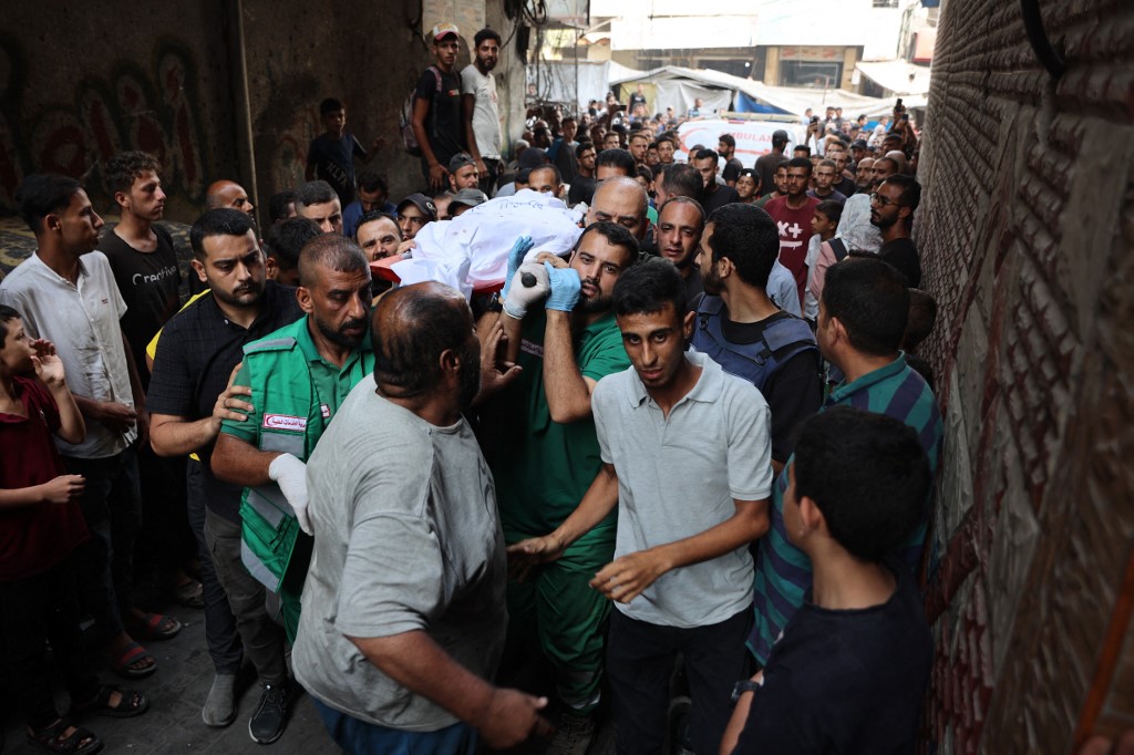 Mourners carry the body of Al Jazeera correspondent Anas al-Sharif, who was killed alongside other journalists in an overnight Israeli strike on their tent in Gaza City, during his funeral in Gaza City on August 11, 2025. 