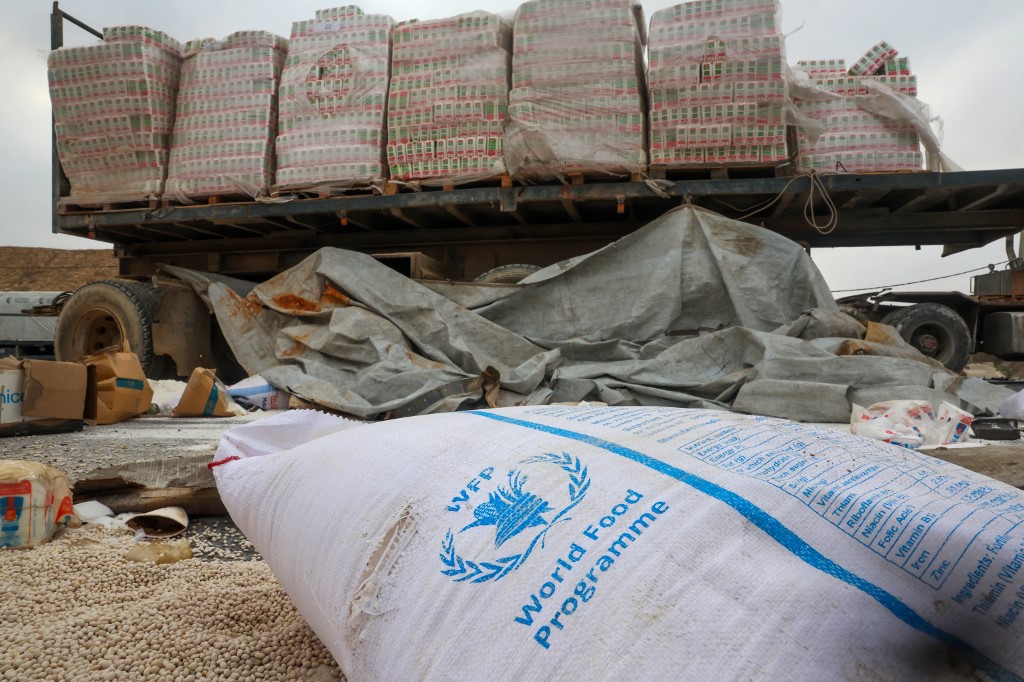 Damaged humanitarian aid for Palestinians in Gaza lies scattered on the ground next to broken-down trucks near the border with the Gaza Strip, close to the Kissufim crossing in southern Israel, on August 13, 2025