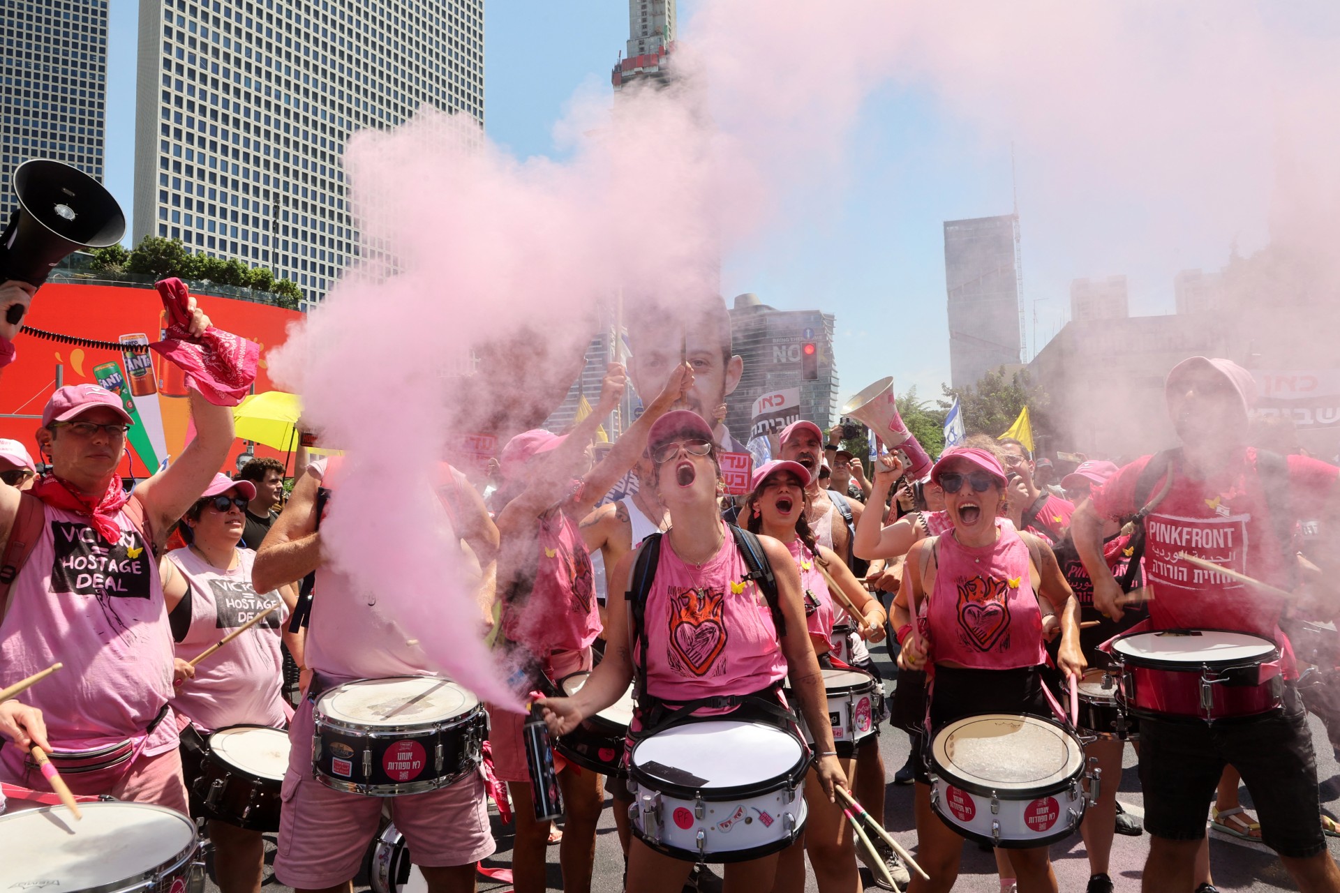 Demonstrators use flares as they drum and shout slogans during a protest in Tel Aviv calling for a Gaza ceasefire deal (AFP/Gil Cohen-Magen)