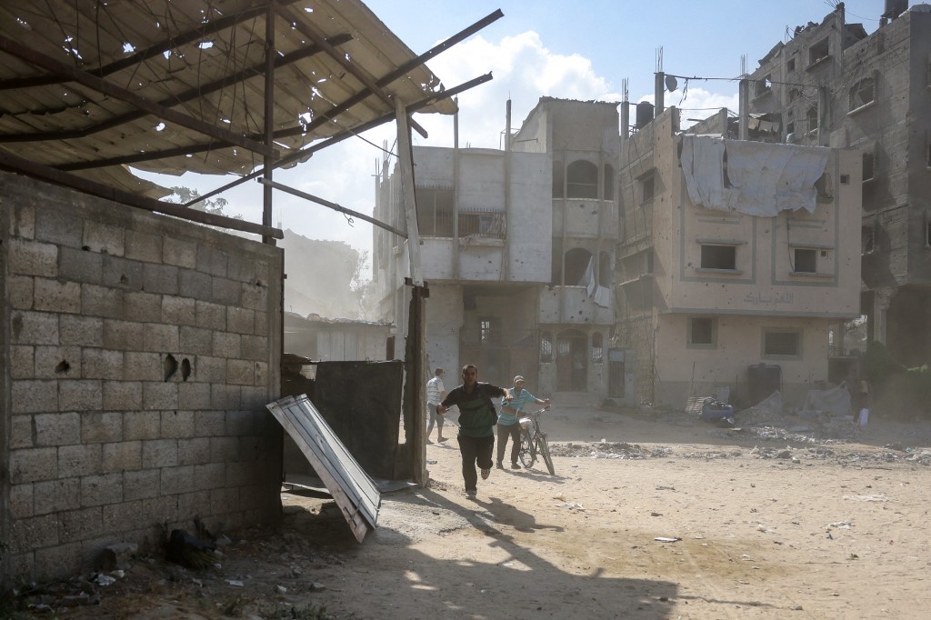 Palestinians run for cover following an explosion in the Saftawi neighbourhood, west of Jabalia in the northern Gaza Strip on August 25, 2025, amid the ongoing war between Israel and the Palestinian militant group Hamas.