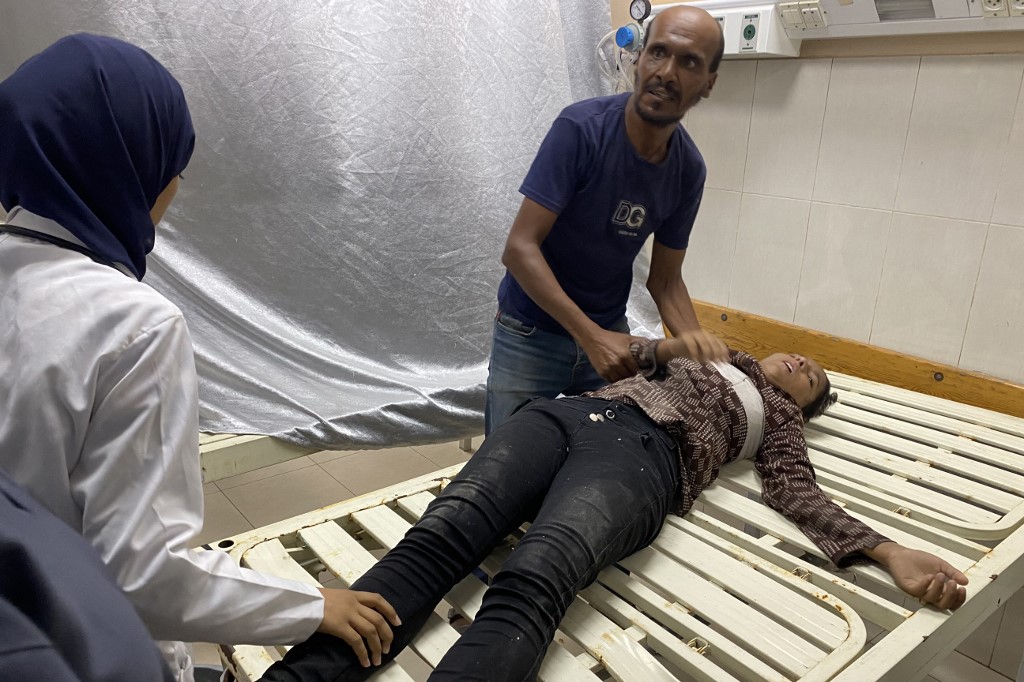Palestinian medics care for a woman who was injured in Israeli strikes on Nasser hospital in Khan Yunis in the southern Gaza Strip on August 25, 2025, with reports stating several killed including journalists. 
