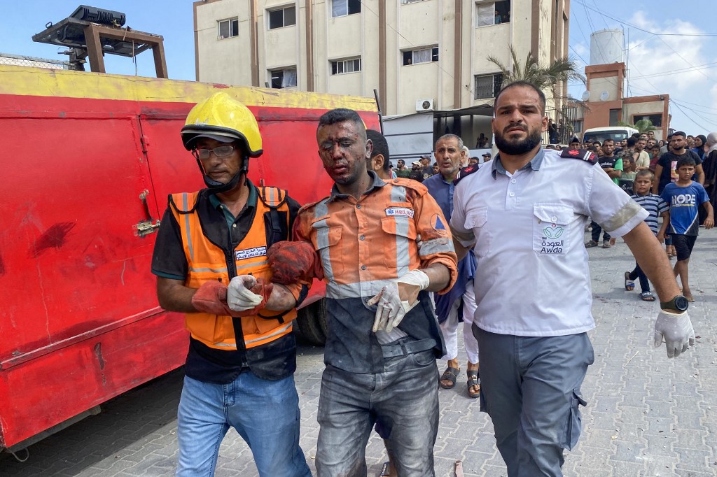 Palestinian medics evacuate a member of the Civil Defence who was injured in Israeli strikes on Nasser hospital in Khan Yunis in the southern Gaza Strip on August 25, 2025, with reports stating several killed including journalists.