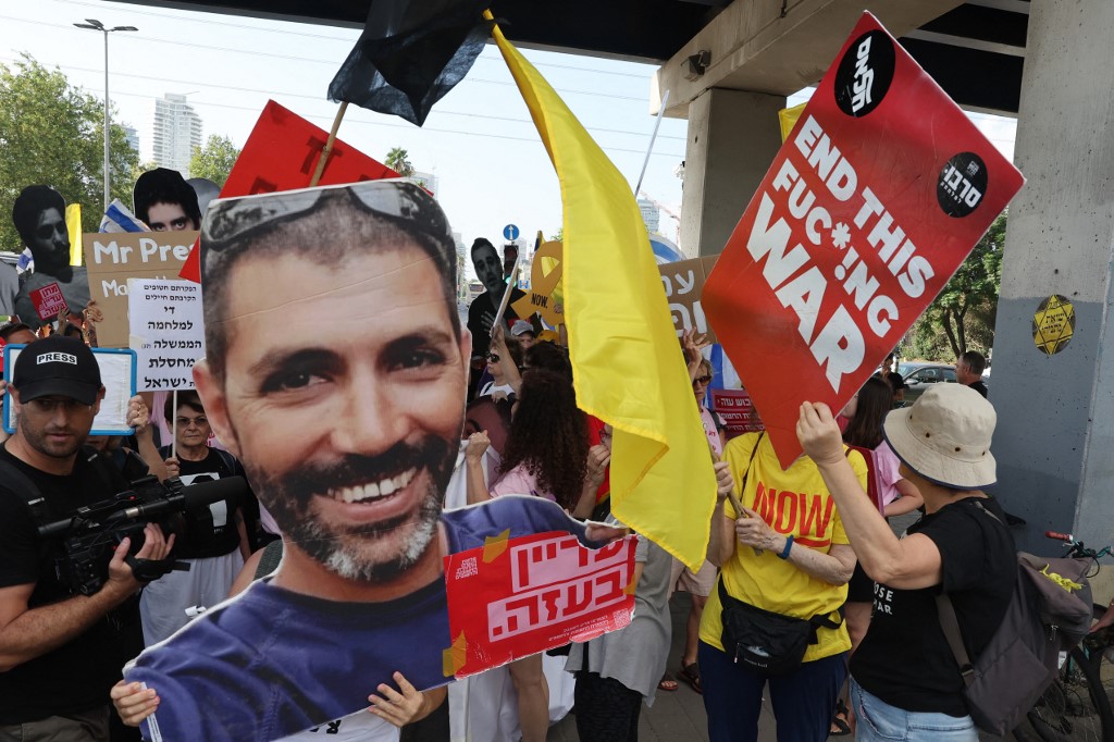 Protesters gather with signs during a demonstration organised by the families of the Israeli hostages taken captive in the Gaza Strip since the October 2023 calling for action to secure their release and a ceasefire in the war against Hamas in Tel Aviv on August 26, 2025.