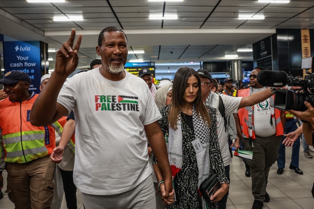 Mandla Mandela (L), South African activist and grandson of the late Nelson Mandela shows a peace sign accompanied by his wife Rabia Mandela (R) as he arrives with others at OR Tambo International Airport in Kempton Park on October 8, 2025