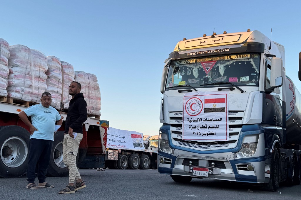 Trucks loaded with humanitarian aid on the Egyptian side of the Rafah crossing wait to cross into the Gaza Strip early on October 15, 2025, after Israel said it would allow the crossing to reopen for humanitarian aid to enter from Egypt into the Palestinian territory. 