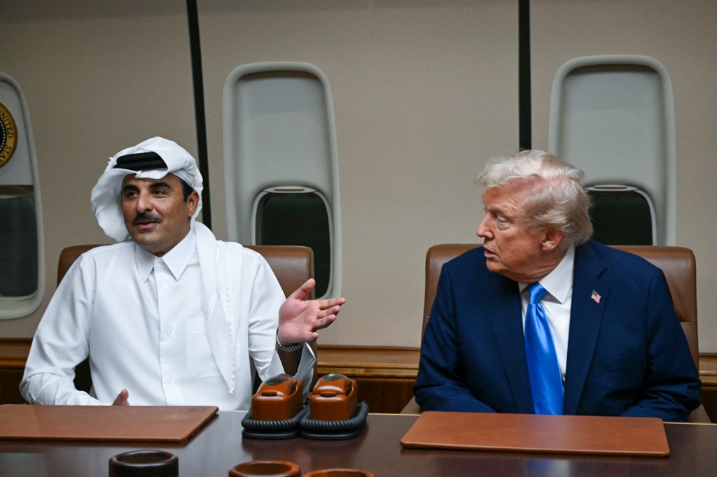 US President Donald Trump listens to Qatar’s Emir Sheikh Tamim bin Hamad Al-Thani during a meeting aboard Air Force One in Doha on October 25, 2025, as he makes a refuelling stop on his way to Malaysia for the ASEAN summit.
