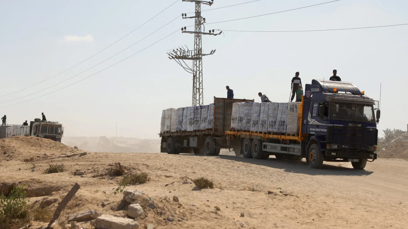 One of 10 aid trucks drive along a dusty road after entering through the Kissufim crossing in southern Israel, towards Deir al-Balah, in the central Gaza Strip on 27 October 2025 (AFP/Bashar Taleb)
