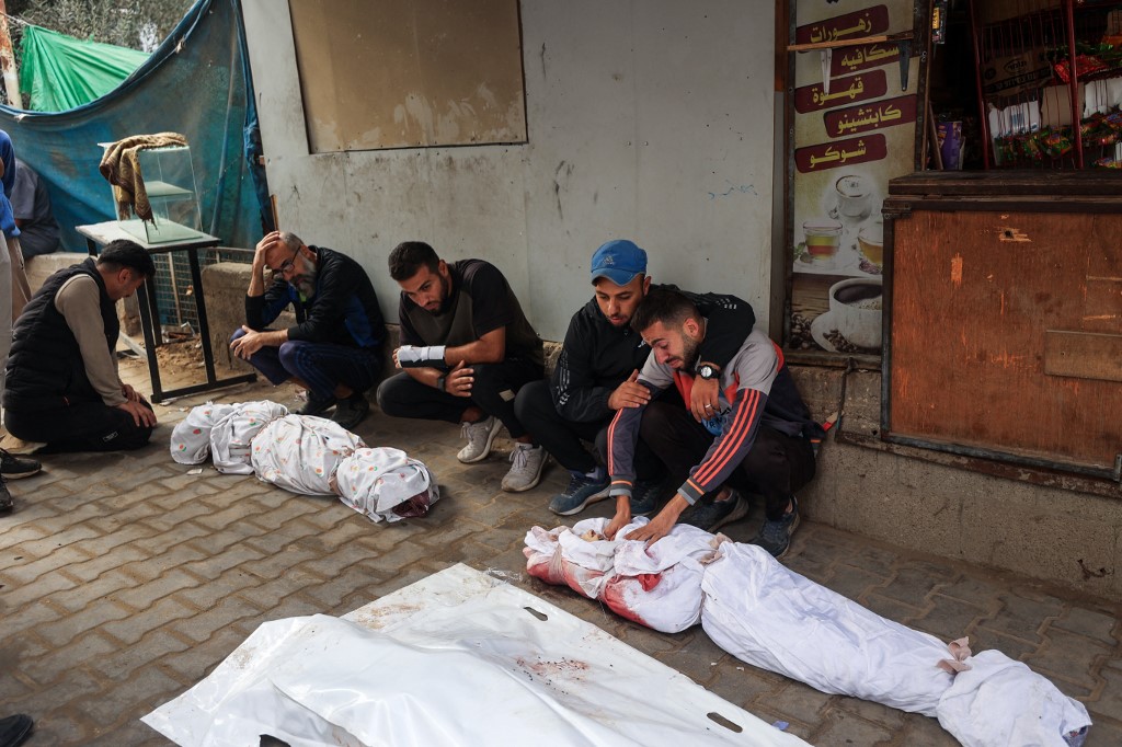 Relatives mourn over the bodies of children killed in an Israeli strike, in Nuseirat in the central Gaza Strip, on October 29, 2025. 