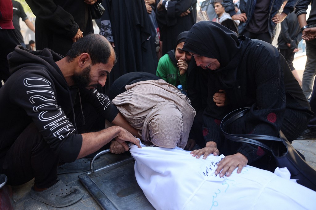 Displaced Palestinians mourn the death of a relative killed in Israeli strikes, outside Al-Shifa Hospital in Gaza City on 20 November, 2025. (AFP)