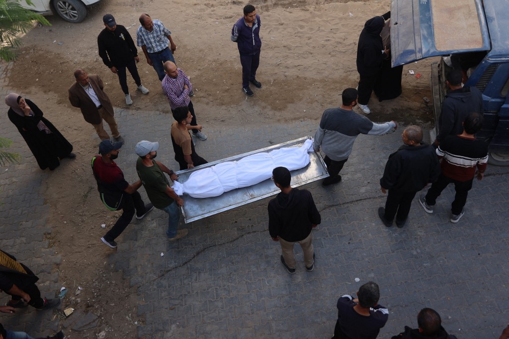 Mourners carry a body during the funeral of a Palestinian, who according to medics, was killed the day before in an Israeli military strike, from the Al-Shifa Hospital, in Gaza City on November 23, 2025. 