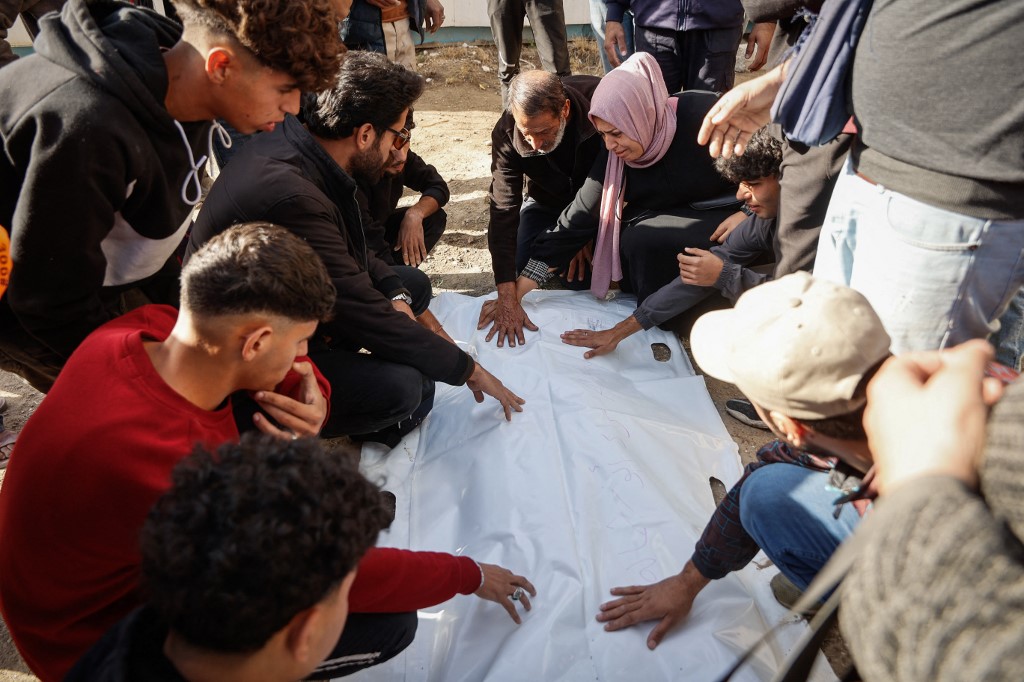 Civil defence personnel and relatives exhume graves inside the Al-Ahli Arab Baptist Hospital to transfer the remains to official burial sites in Gaza City on 7 December, 2025. (AFP)