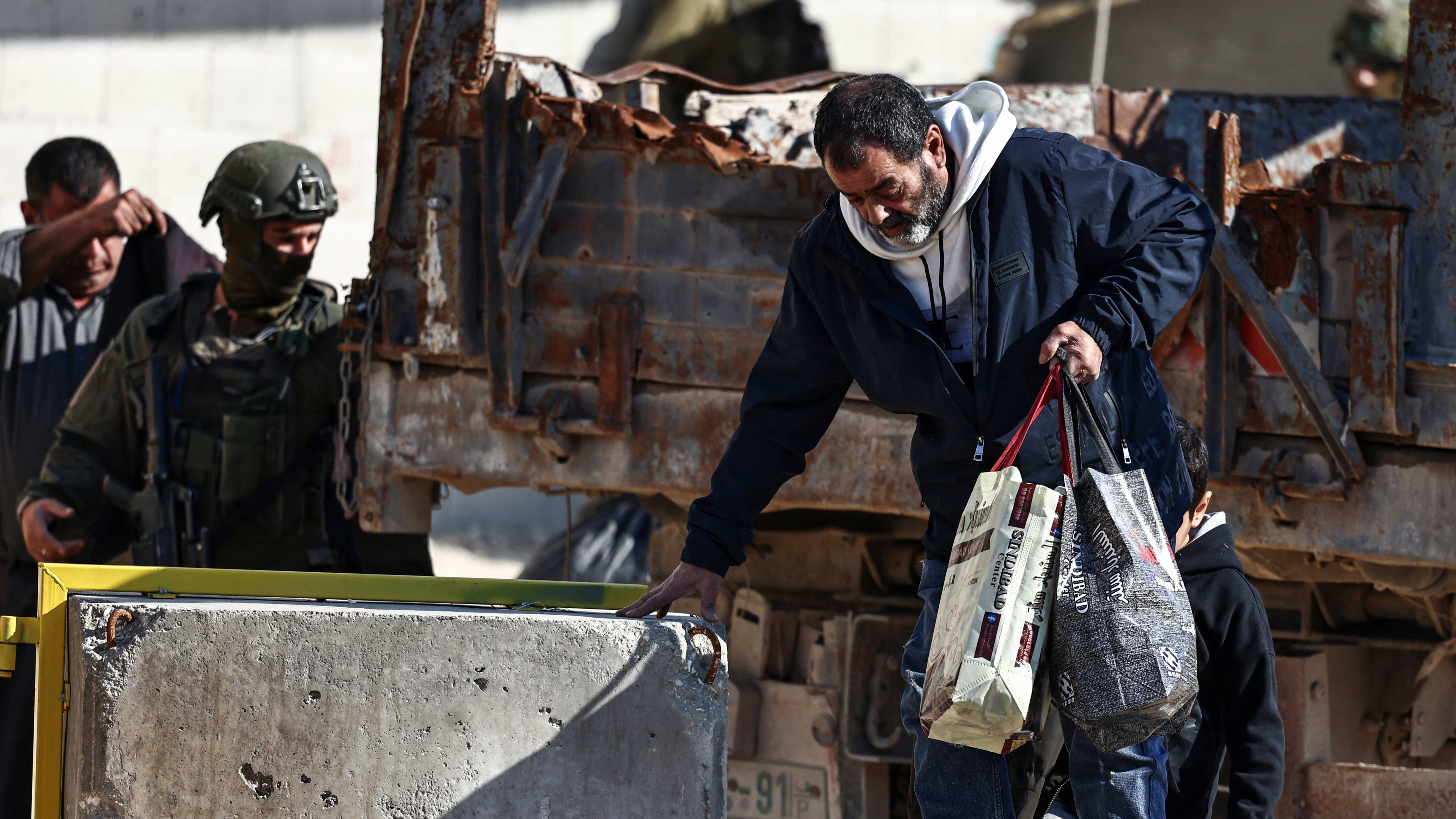A resident of the Nur Shams refugee camp carries belongings retrieved from his home ahead of the Israeli military’s demolition, 17 December 2025 (AFP/ Zain Jaafar)