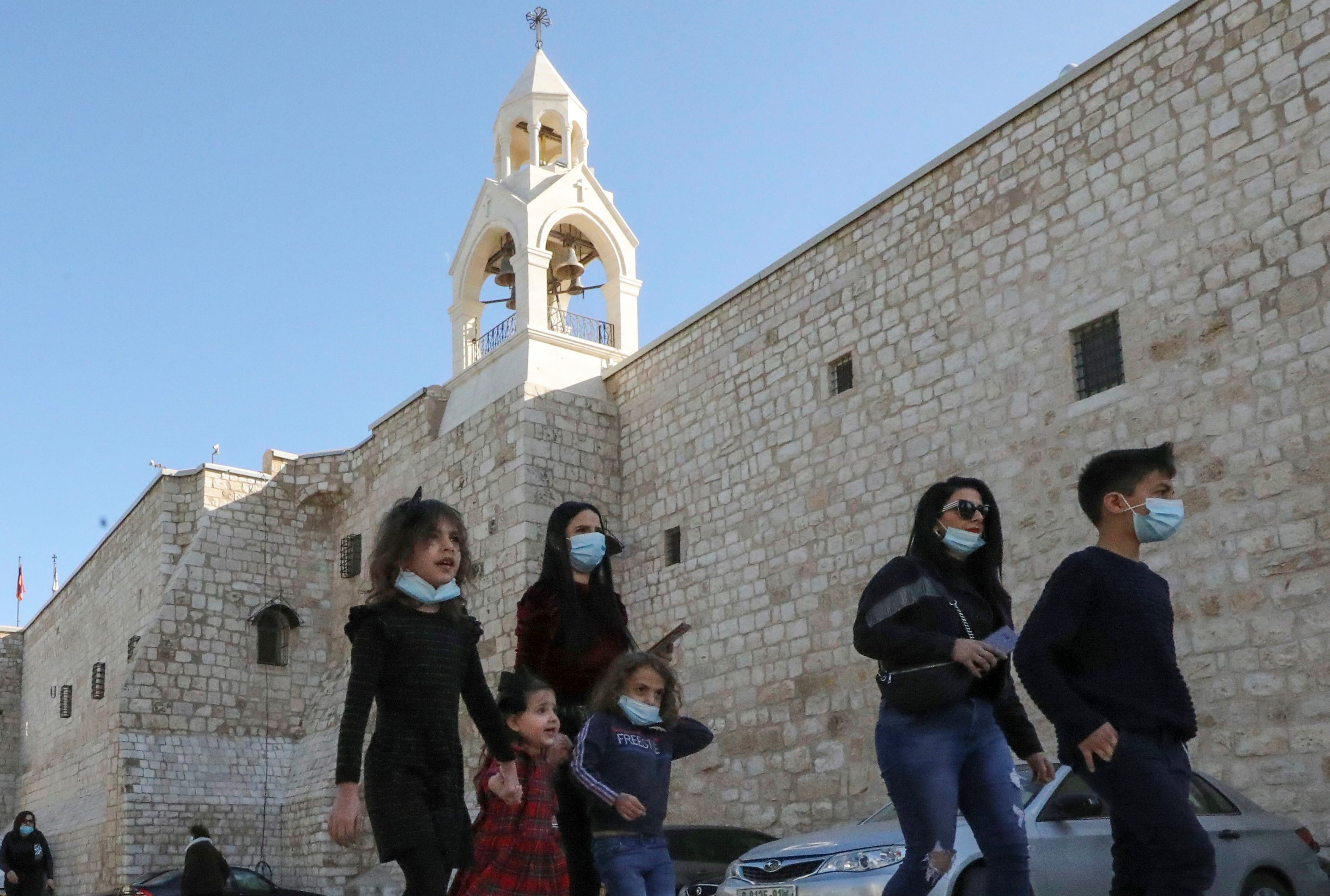  Worshippers leave after Sunday mass at the Church of the Nativity, in the biblical city of Bethlehem in the Israeli-occupied West Bank, on 20 December