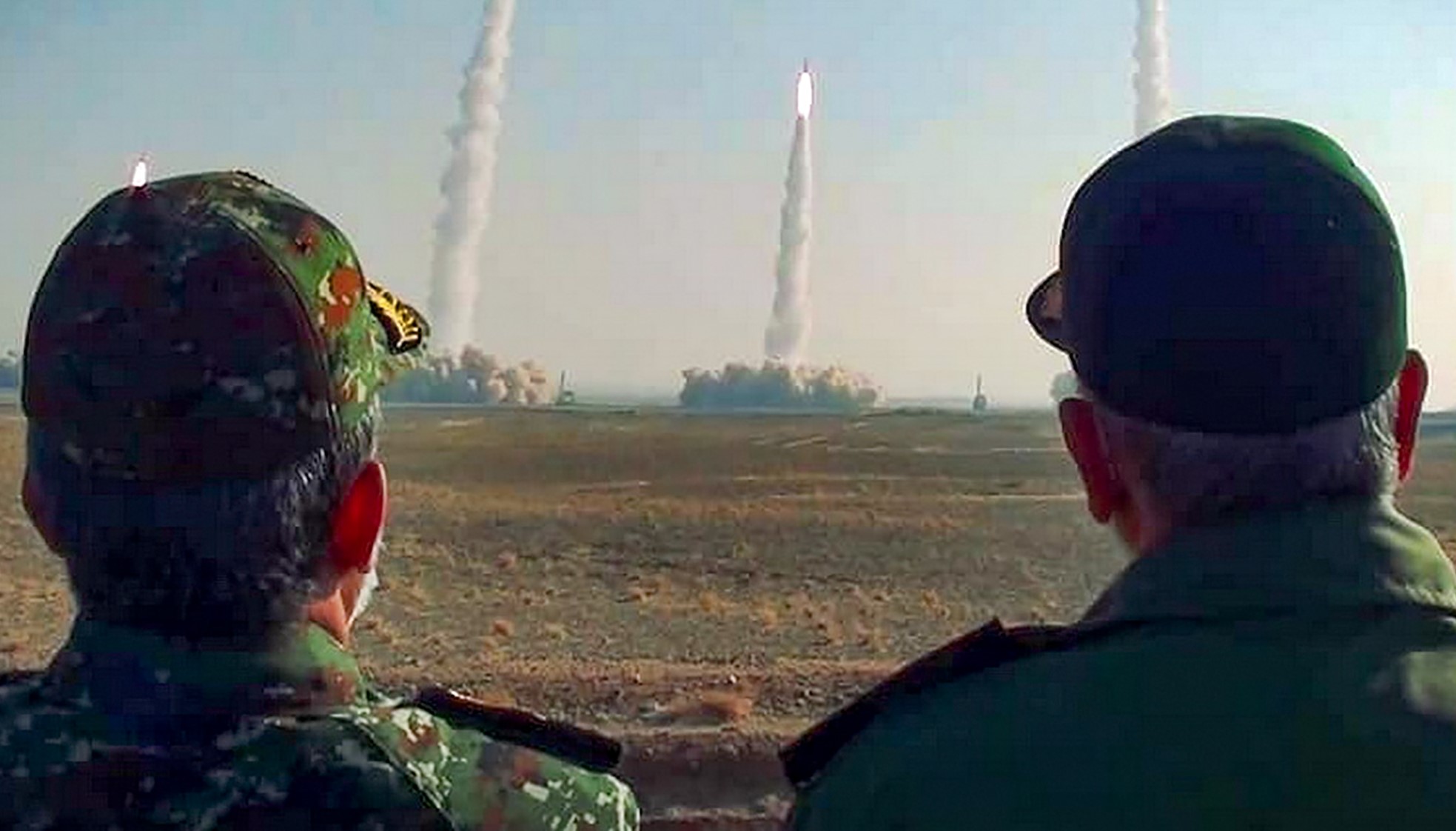 the head of Iran's Revolutionary Guard Corps Hossein Salami (R) watching a launch of missiles during a military drill in an unknown location in central Iran