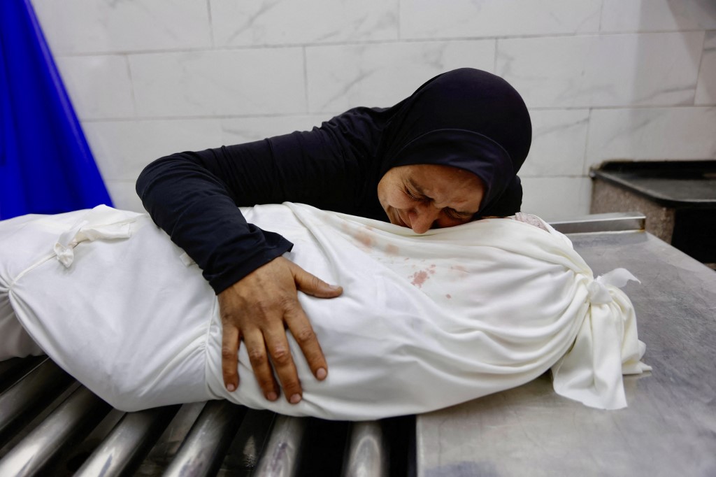 Palestinian Asma al-Zawarah, 37, hugs her son 15-year-old, Mohammed, after he was killed along with his 13-year-old cousin in an Israeli drone strike, at the morgue of the al-Shifa Hospital in Gaza City, on January 24, 2026. 