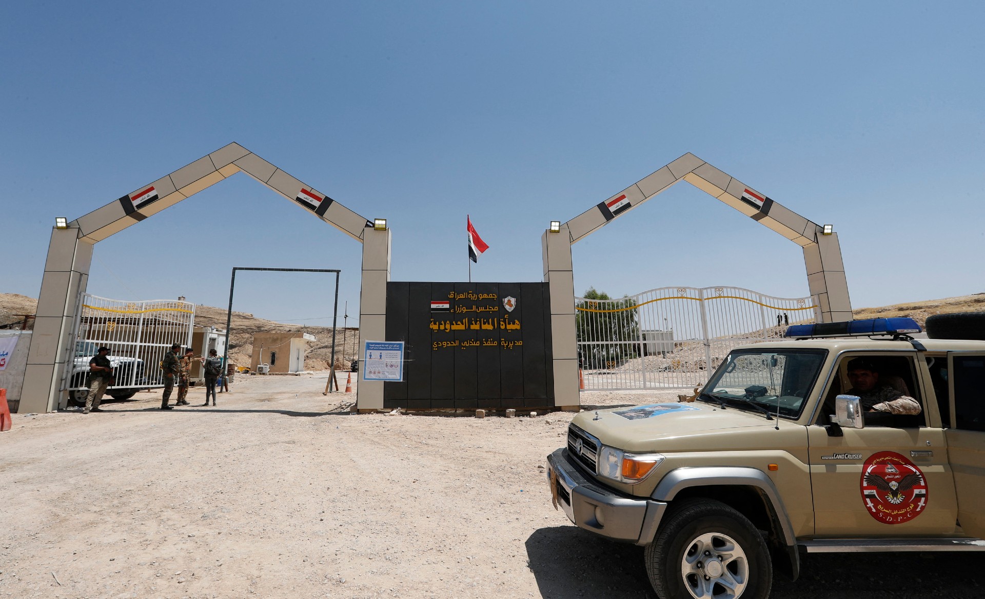 Members of the Popular Mobilisation paramilitary forces stand guard on the Iraqi side of the Mandali crossing on the border with Iran (AFP)